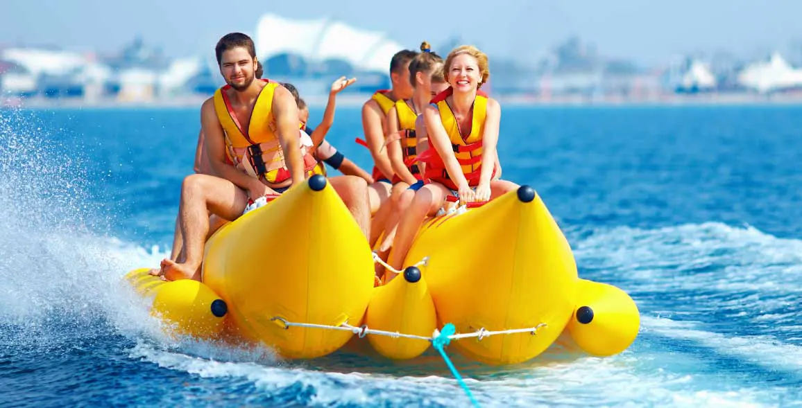 Thrillseekers having adrenaline-pumping experience on banana boat ride in the middle of the water in Dubai